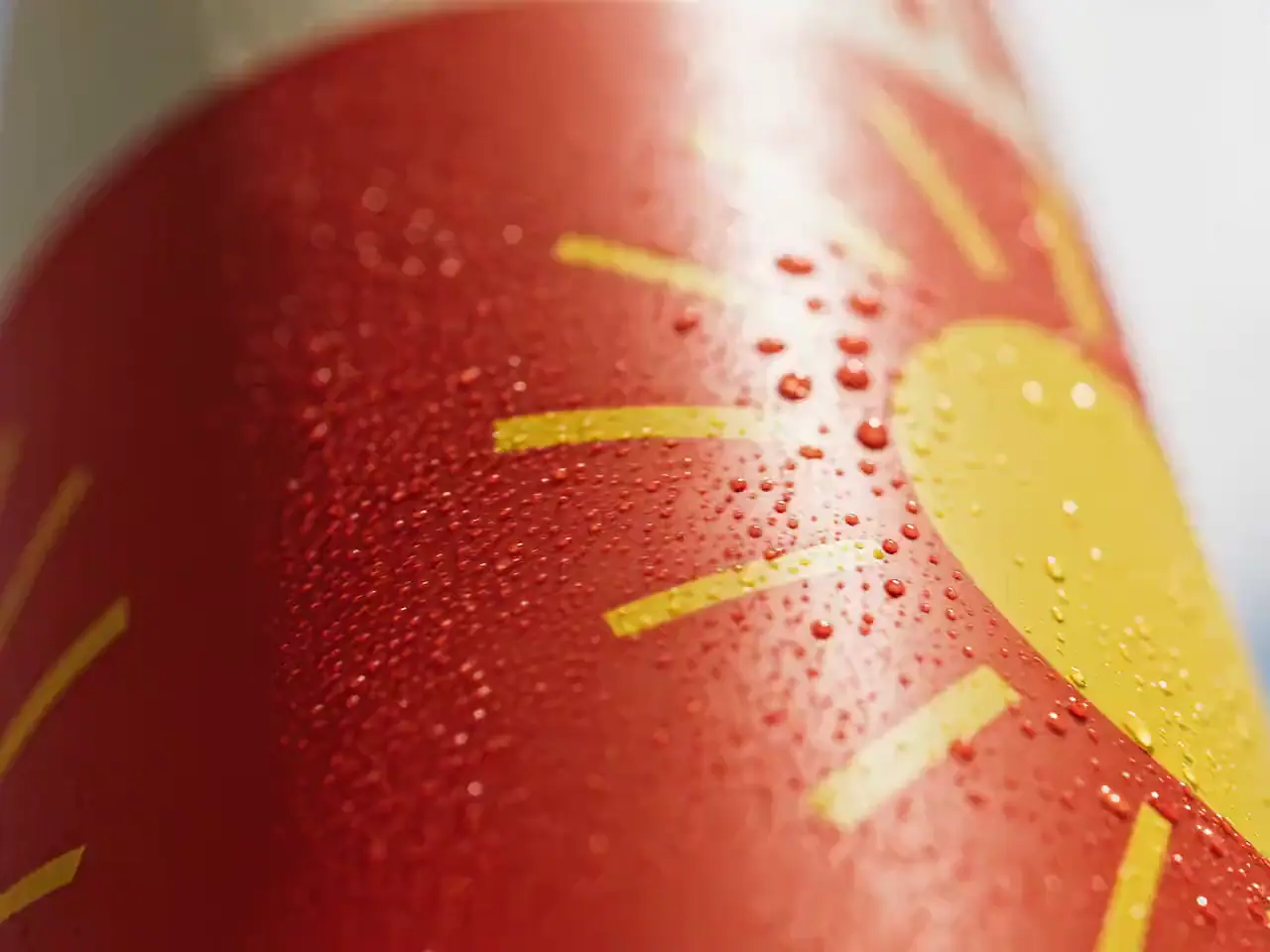 Product advert: close-up of a red citrus soda can with a yellow sun